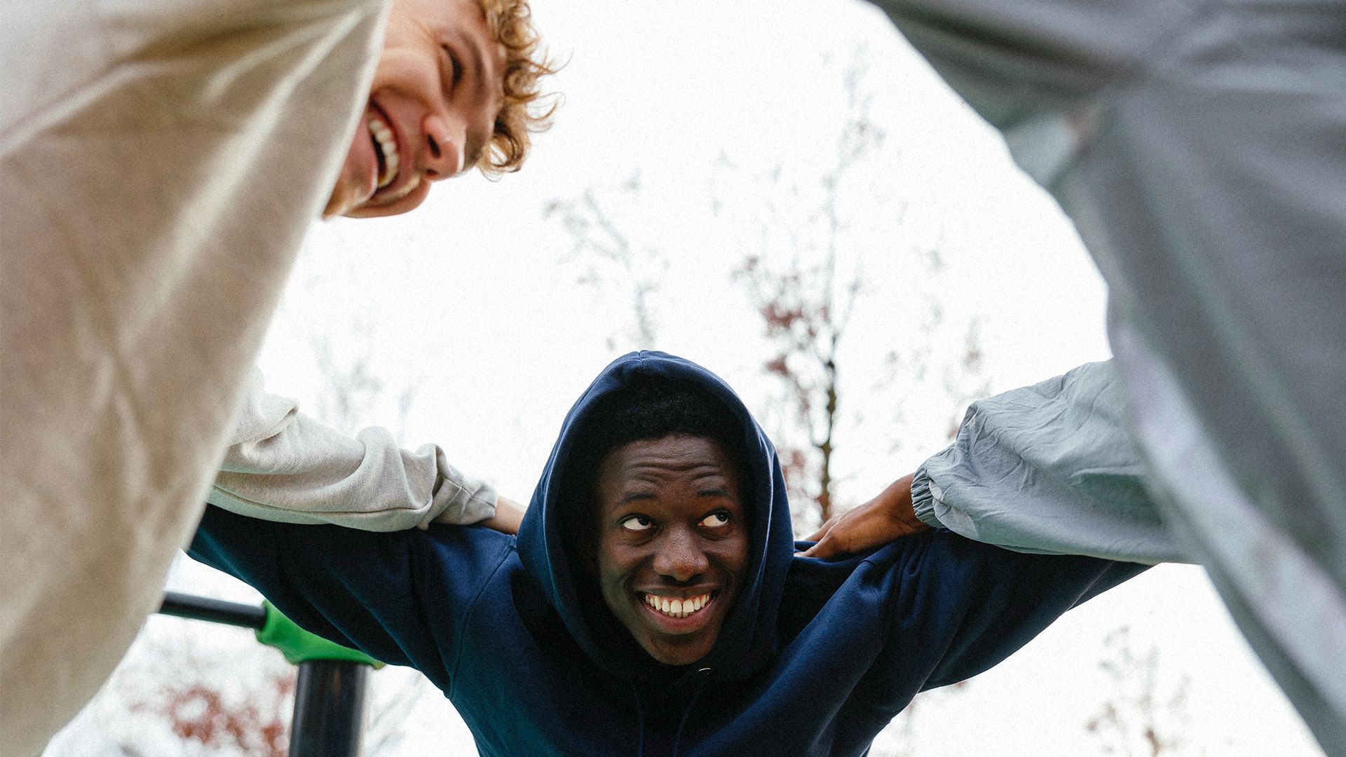 Three men huddled together and smiling