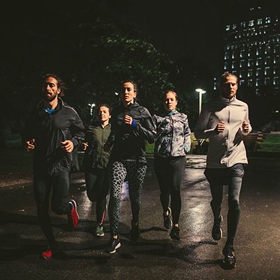 Photo of joggers in activewear running at night.