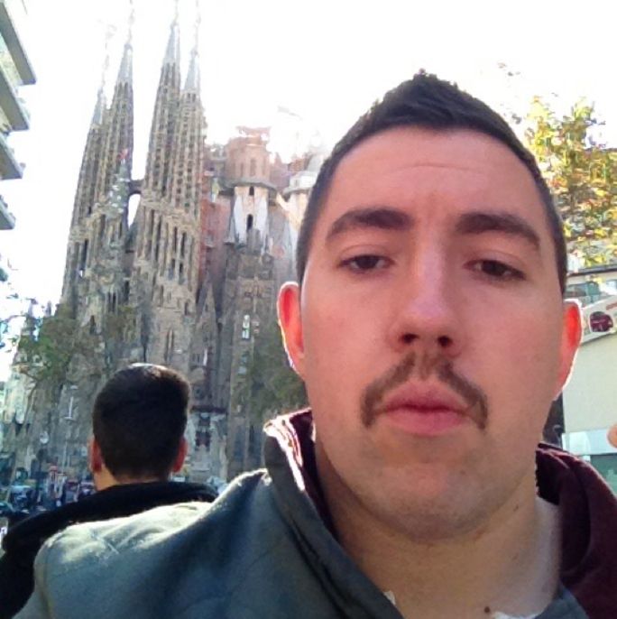 Photo of a man with a classy moustache, looking to camera.